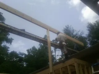 Carpenter setting a ridge beam over a new addition frame — Ice Dam Removal by Roofing Brothers in Soda Springs