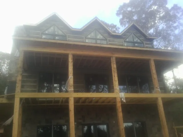 Dormers and porch framing on a large log home under construction — Roof Coating work by our crew in Soda Springs