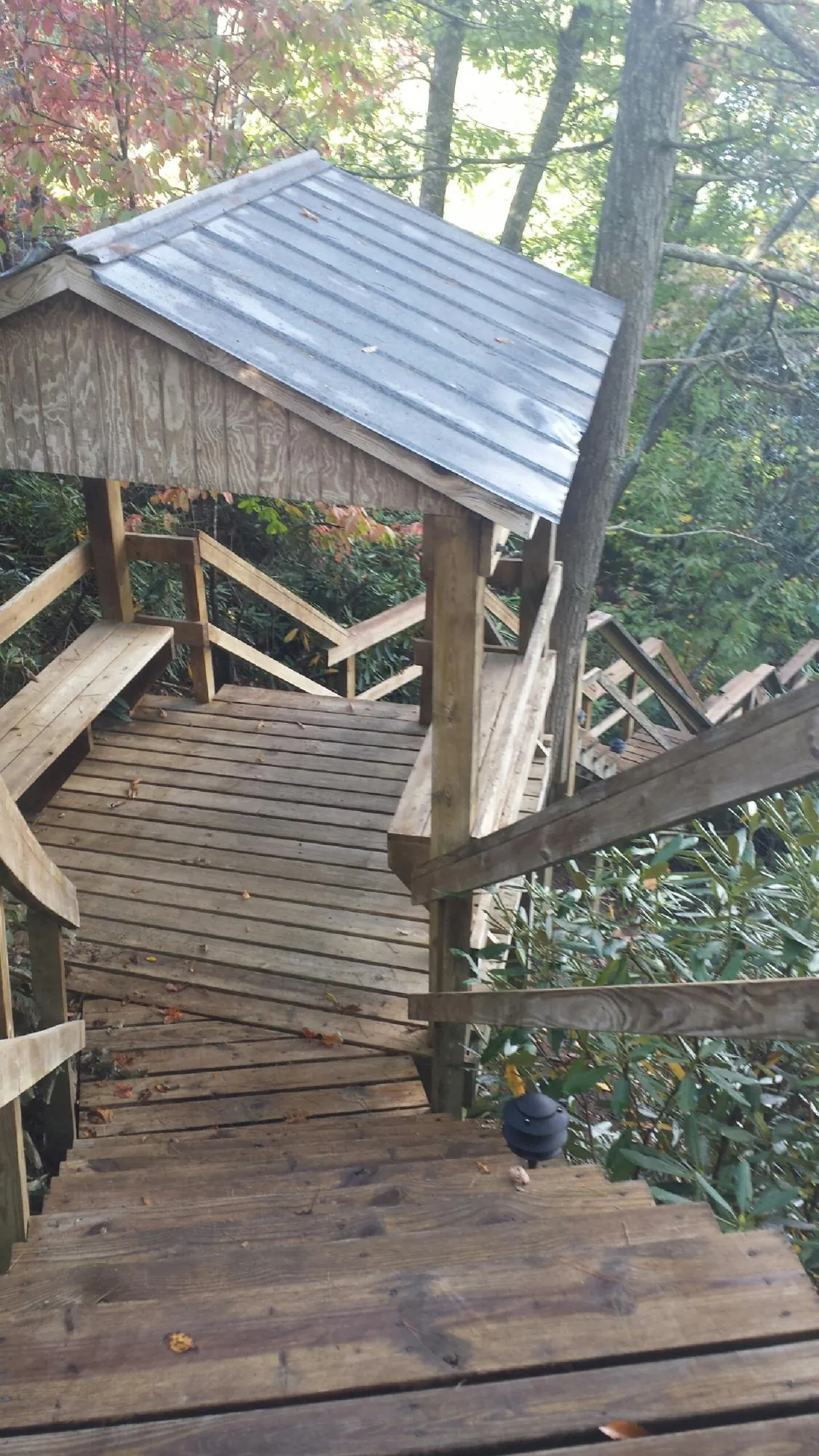 Metal roofed shelter over wooden steps on a wooded walkway — Skylight Repair & Installation work by our crew in Soda Springs